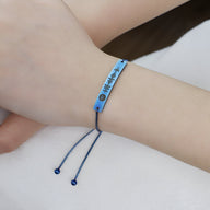 Bracelet gourmette ajustable bleu avec design Spotify gravé et cordon coulissant bleu.
