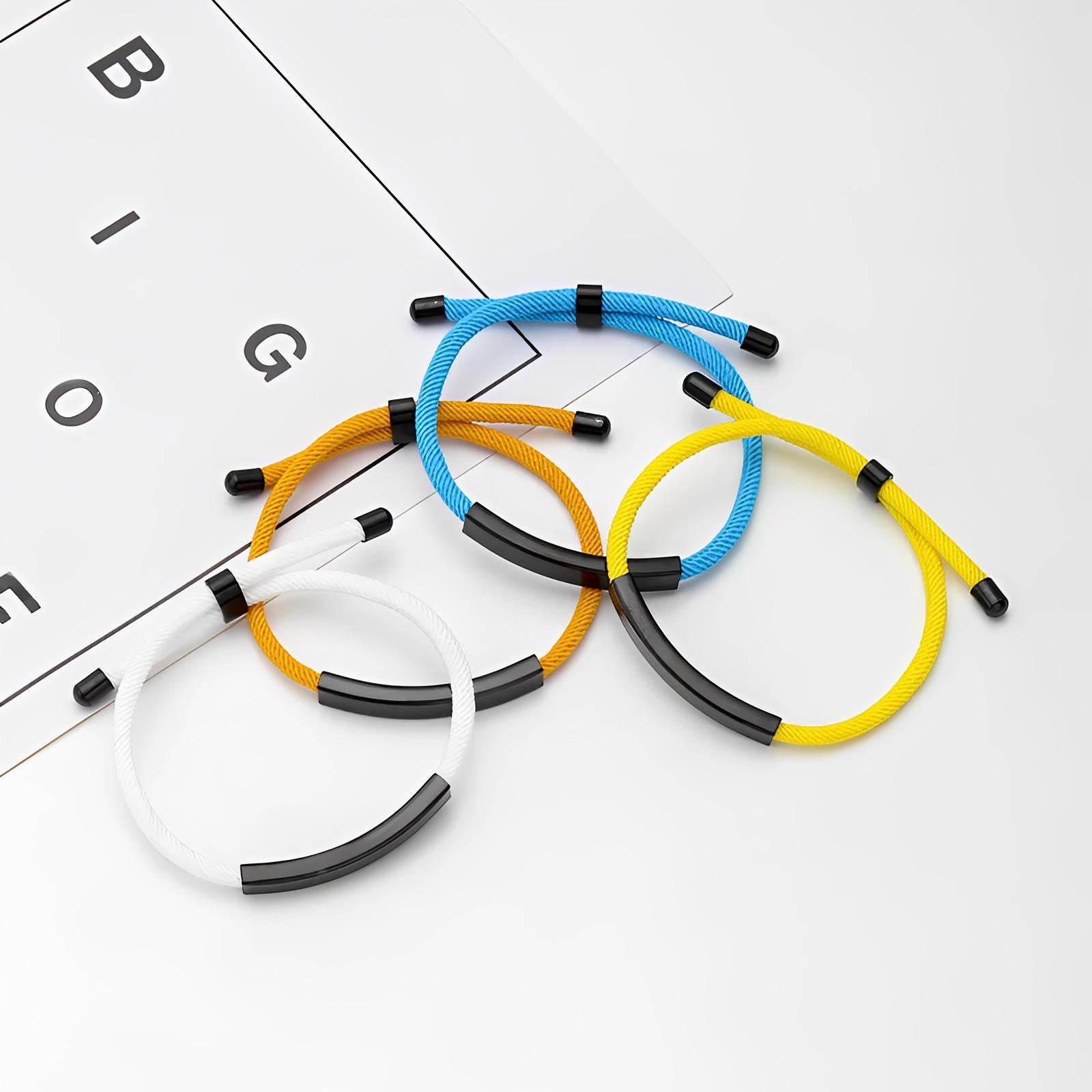 Bracelets cordon nylon colorés avec barre en acier inoxydable et fermoir coulissant, styles bleu, jaune, blanc et noir.