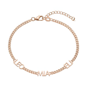Bracelet en acier inoxydable doré rose avec chaîne maille cubaine fine et trois prénoms taillés LEO, MIA, TI.