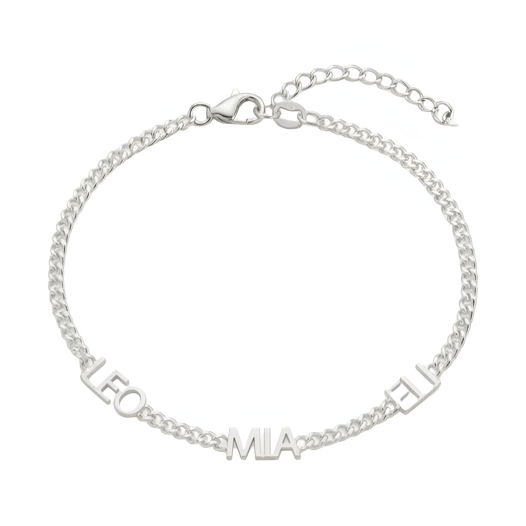 Bracelet en acier inoxydable argenté avec maille cubaine fine et trois prénoms découpés, fermoir cœur ajustable.