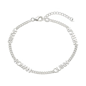 Bracelet en acier inoxydable argenté avec maille cubaine fine et quatre prénoms taillés autour du poignet.