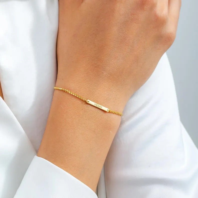 Bracelet gourmette maille vénitienne en acier inoxydable doré avec plaque personnalisable, style mixte, porté au poignet.