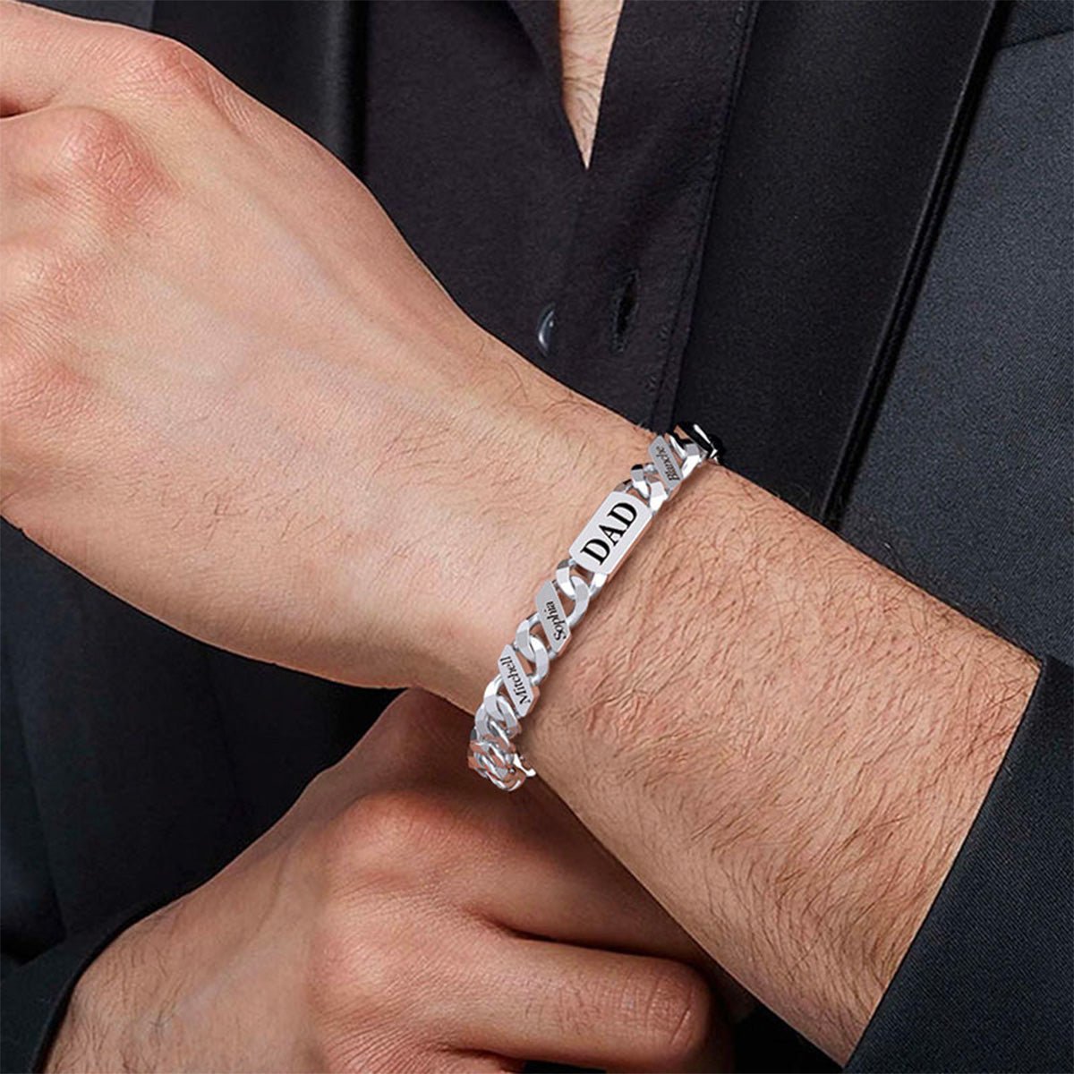 Bracelet en acier inoxydable à maille cubaine large, plaque gravée de prénoms, finition brillante, style masculin élégant.