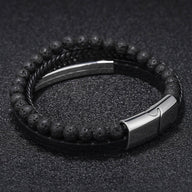 Bracelet double tour en cuir noir tressé avec perles volcaniques noires et fermoir métallique argenté gravé.