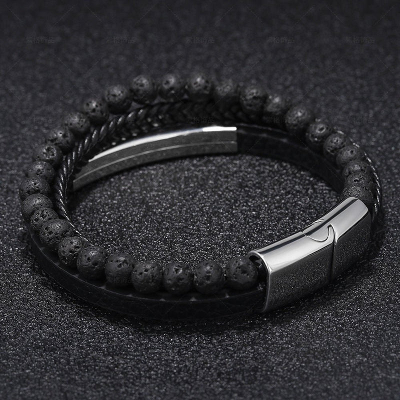 Bracelet double tour en cuir noir tressé avec perles volcaniques noires et fermoir métallique argenté gravé.