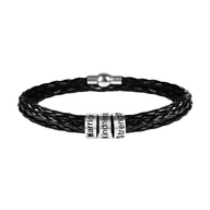 Bracelet triple tour en cuir noir tressé avec trois anneaux à graver en métal argenté et fermoir magnétique.