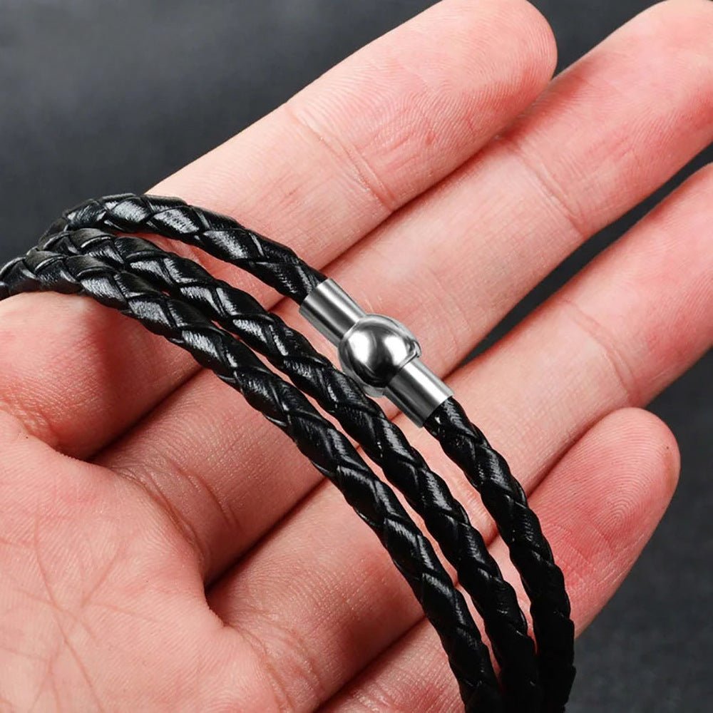 Bracelet noir triple tour en cuir tressé avec fermoir métallique rond et plusieurs anneaux à graver.