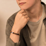 Bracelet mixte en pierres naturelles œil de tigre, perles rondes lisses sur poignet peau claire.