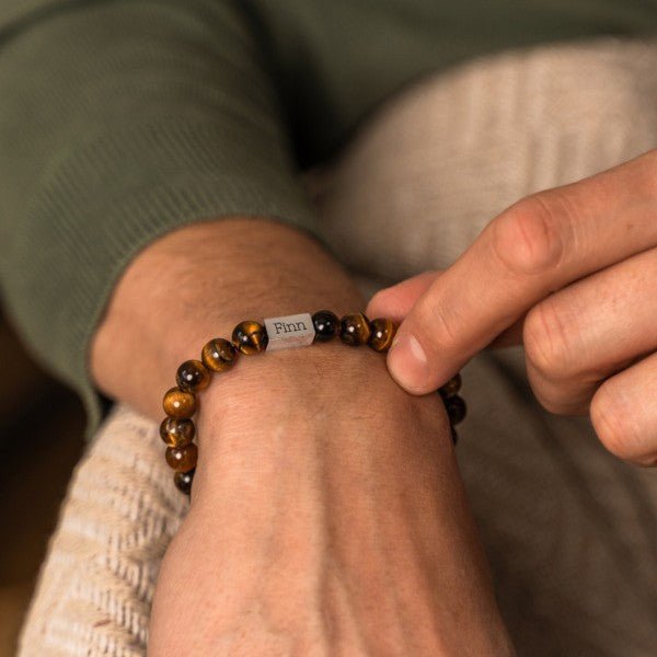 Bracelet mixte en pierres naturelles œil de tigre avec étiquette métallique gravée.