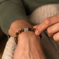 Bracelet mixte en pierres naturelles œil de tigre avec étiquette métallique gravée.