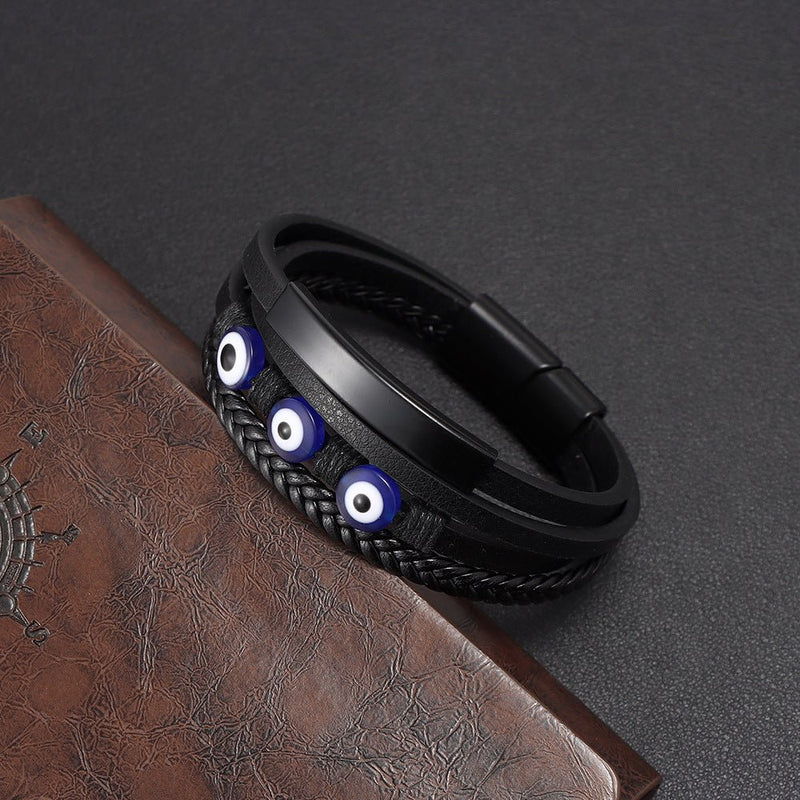 Bracelet homme cuir noir multi-rangs avec œil protecteur bleu et fermoir magnétique style moderne.
