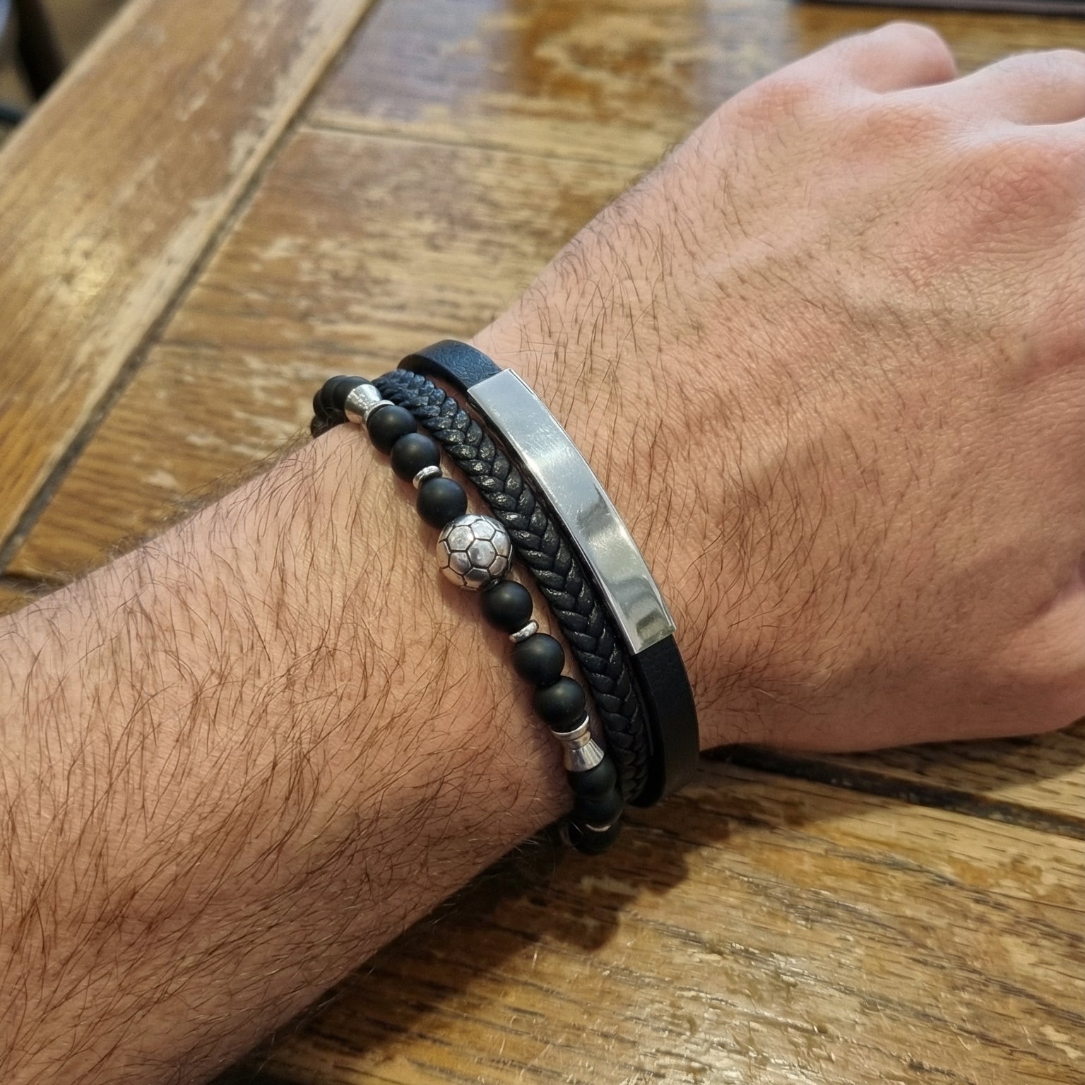 Bracelet homme cuir noir tressé avec perles noires et argentées, fermoir magnétique acier, motif ballon de foot.