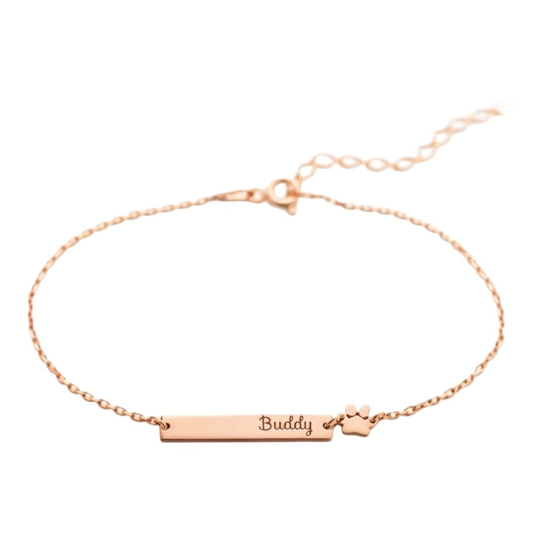Bracelet chaîne fine en acier inoxydable doré avec plaque gravée "Buddy" et motif patte d'animal.