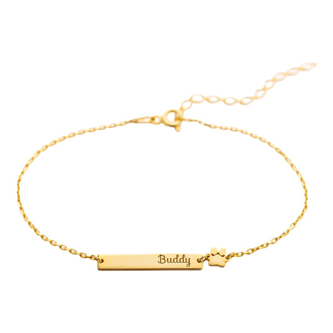 Bracelet fin doré avec plaque gravée "Buddy" et motif patte d'animal en acier inoxydable.