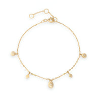 Bracelet en or avec fines chaînes et quatre petits pendentifs charms délicats pour femme.