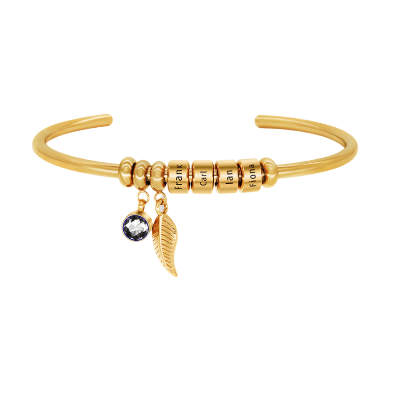 Bracelet doré quatre anneaux avec perles, pendentif feuille et pierre brillante.