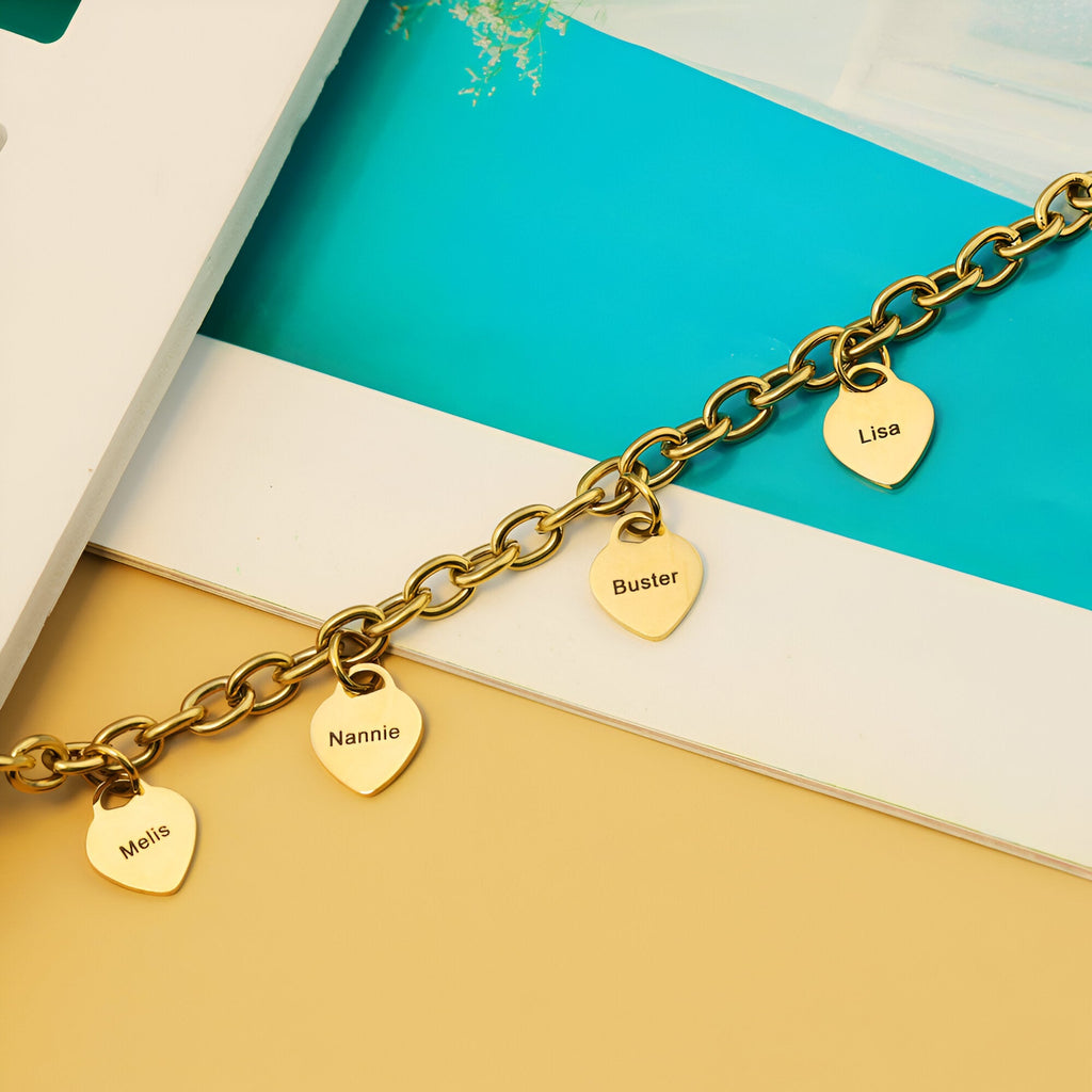 Bracelet chaîne en acier inoxydable doré avec quatre plaques cœur gravées de prénoms.