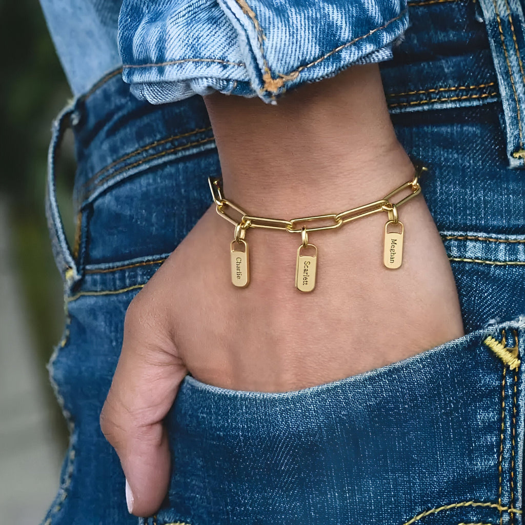 Bracelet femme en acier inoxydable doré à maillons larges avec quatre plaques gravées suspendues.