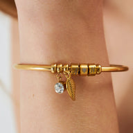 Bracelet fin doré trois anneaux avec pendentifs feuille et pierre brillante en acier inoxydable.