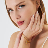 Bracelet trois anneaux doré en acier inoxydable porté au poignet, design élégant et fin.