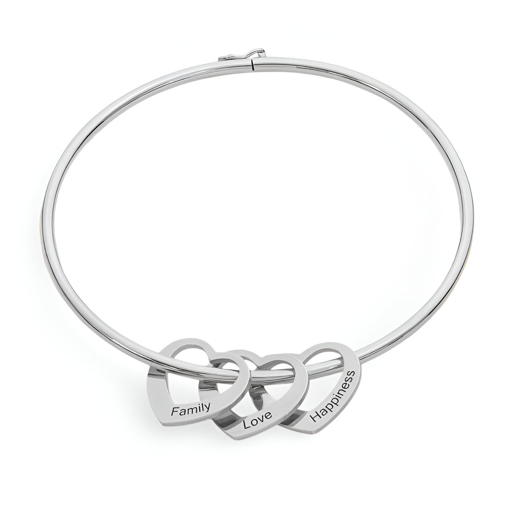 Bracelet rigide en titane argenté avec trois cœurs entrelacés gravés « Family », « Love », « Happiness ».
