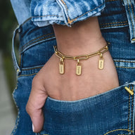 Bracelet femme en acier inoxydable doré avec trois plaques personnalisables et maillons larges.