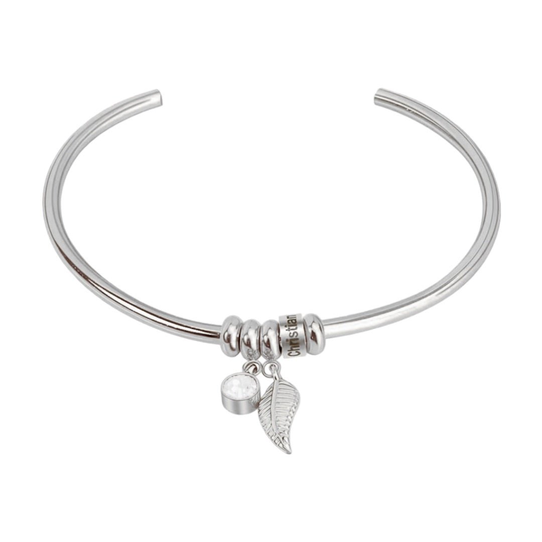 Bracelet jonc en acier inoxydable argenté avec pendentifs plume et cercle lisse.