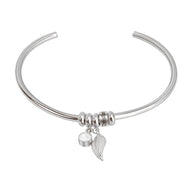 Bracelet jonc en acier inoxydable argenté avec pendentifs plume et cercle lisse.