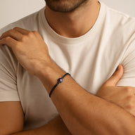 Bracelet à cordon noir réglable en cuir avec pendentif rond en métal argenté et image cachée centrale.