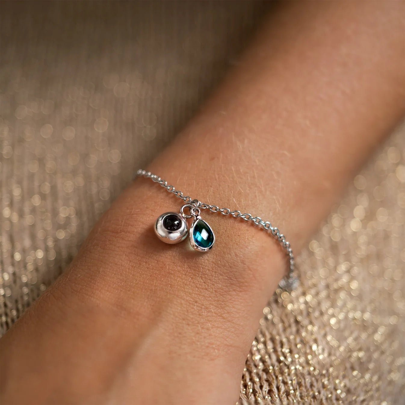 Bracelet chaîne fine en acier inoxydable avec pierre de naissance en goutte bleu et médaillon rond personnalisé.