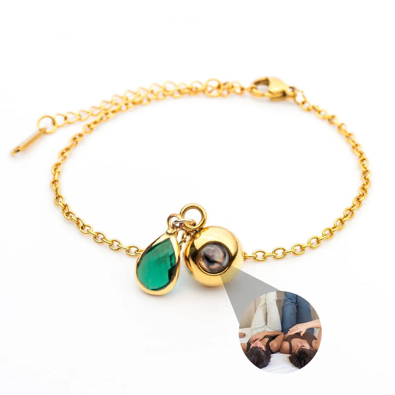 Bracelet fin en acier inoxydable doré avec pendentif photo en forme de goutte et pierre de naissance verte en goutte.