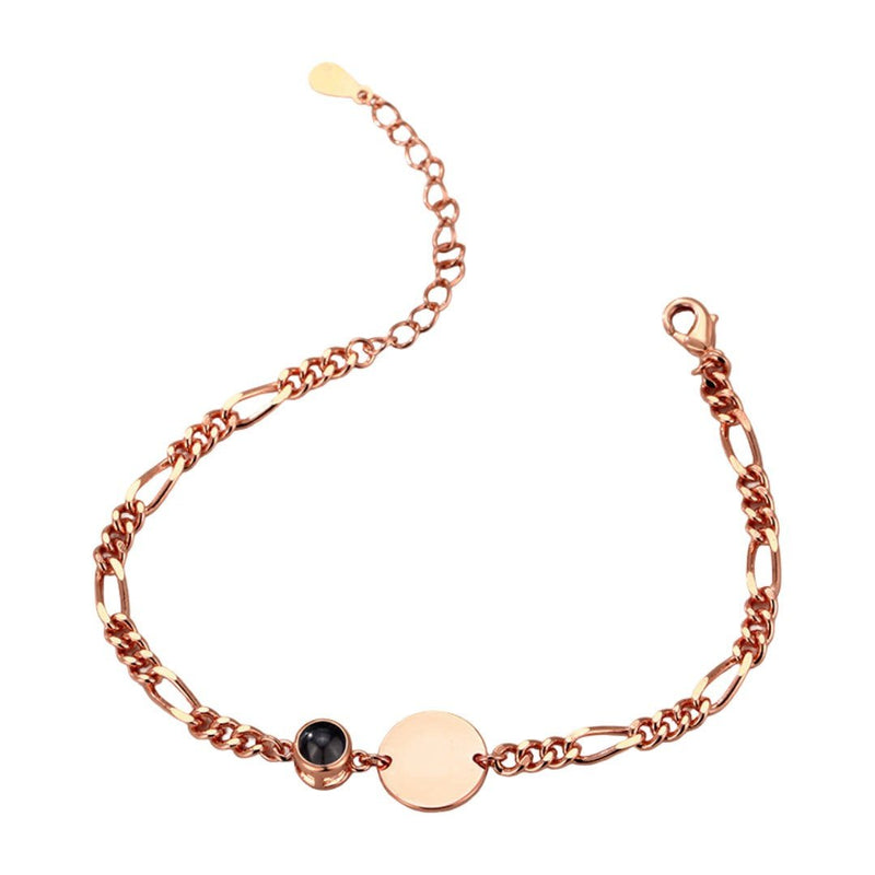 Bracelet en acier couleur or rose avec mailles Figaro, médaille ronde lisse et petit rond noir serti.