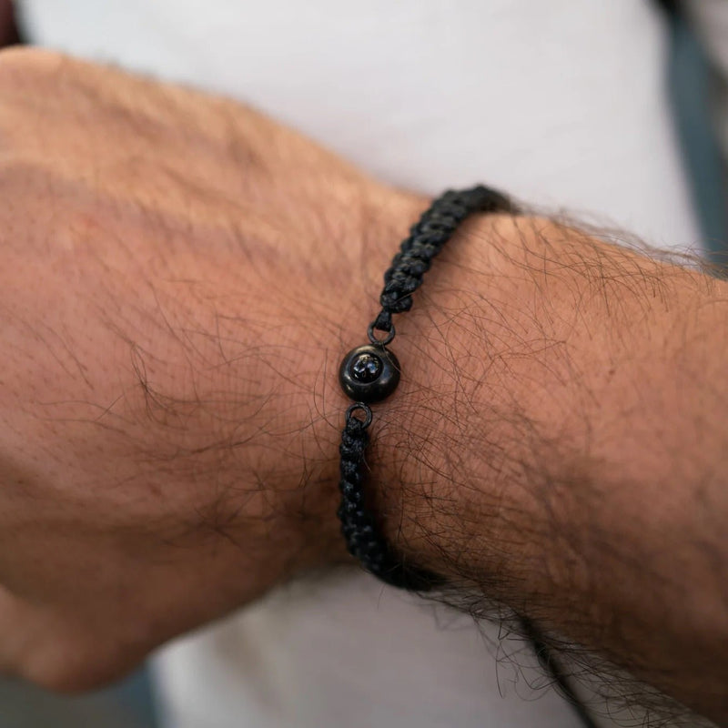 Bracelet homme en corde noire tressée avec bouton en titane noir et gravure personnalisée.