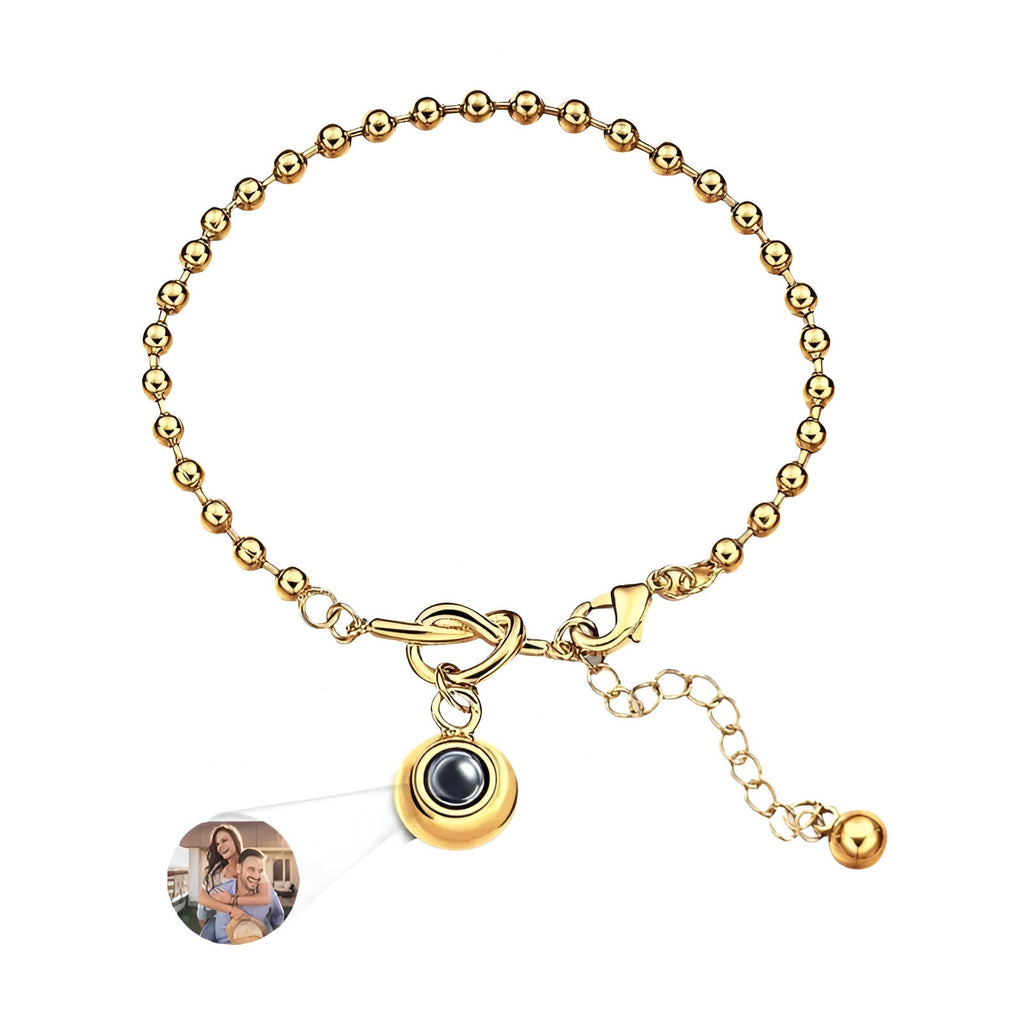 Bracelet femme en acier inoxydable doré à billes avec pendentif photo à nœud central et chaîne réglable.