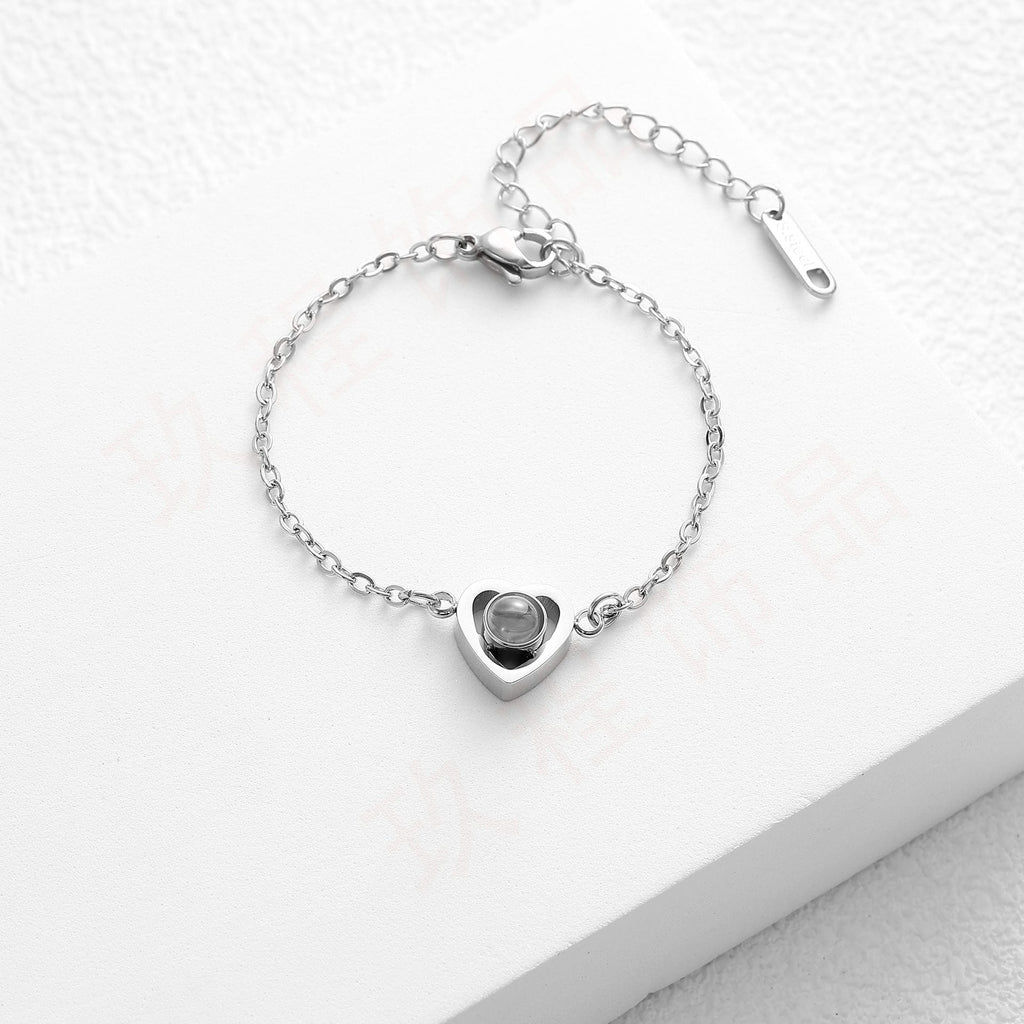 Bracelet en acier inoxydable argenté avec pendentif cœur personnalisable et chaîne fine ajustable.