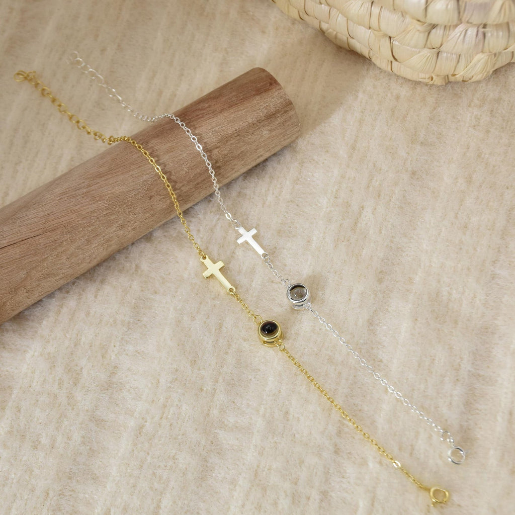 Bracelet en acier inoxydable doré avec croix chrétienne et chaîne fine, style délicat et épuré.