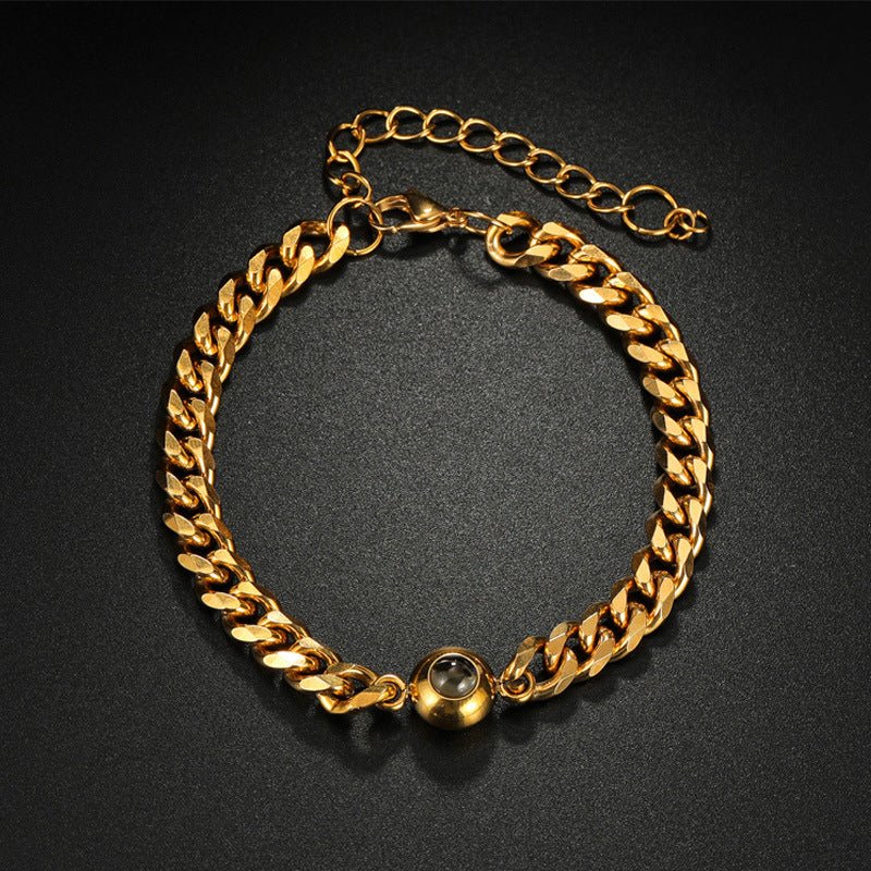 Bracelet maille cubaine doré en acier inoxydable avec boule centrale lisse et chaîne réglable.