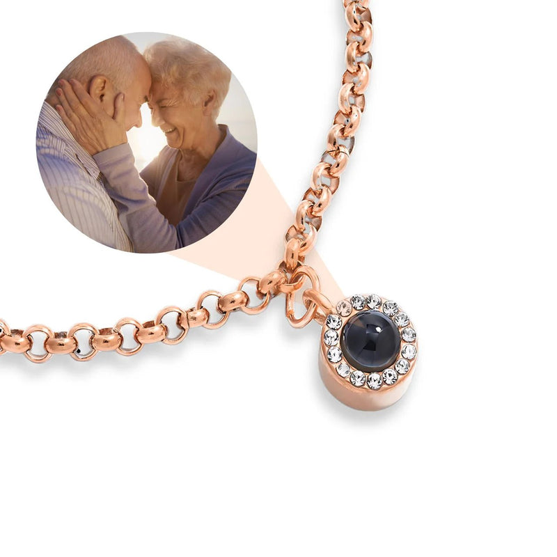 Bracelet en acier inoxydable or rosé à maille rolo avec pendentif rond photo entouré de petits cristaux blancs.