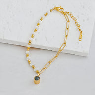 Bracelet or en acier inoxydable avec perles d'eau douce et pendentif rectangulaire vert.