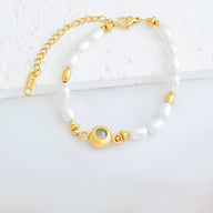 Bracelet or en acier inoxydable avec perles d'eau douce blanches et médaillon photo circulaire.