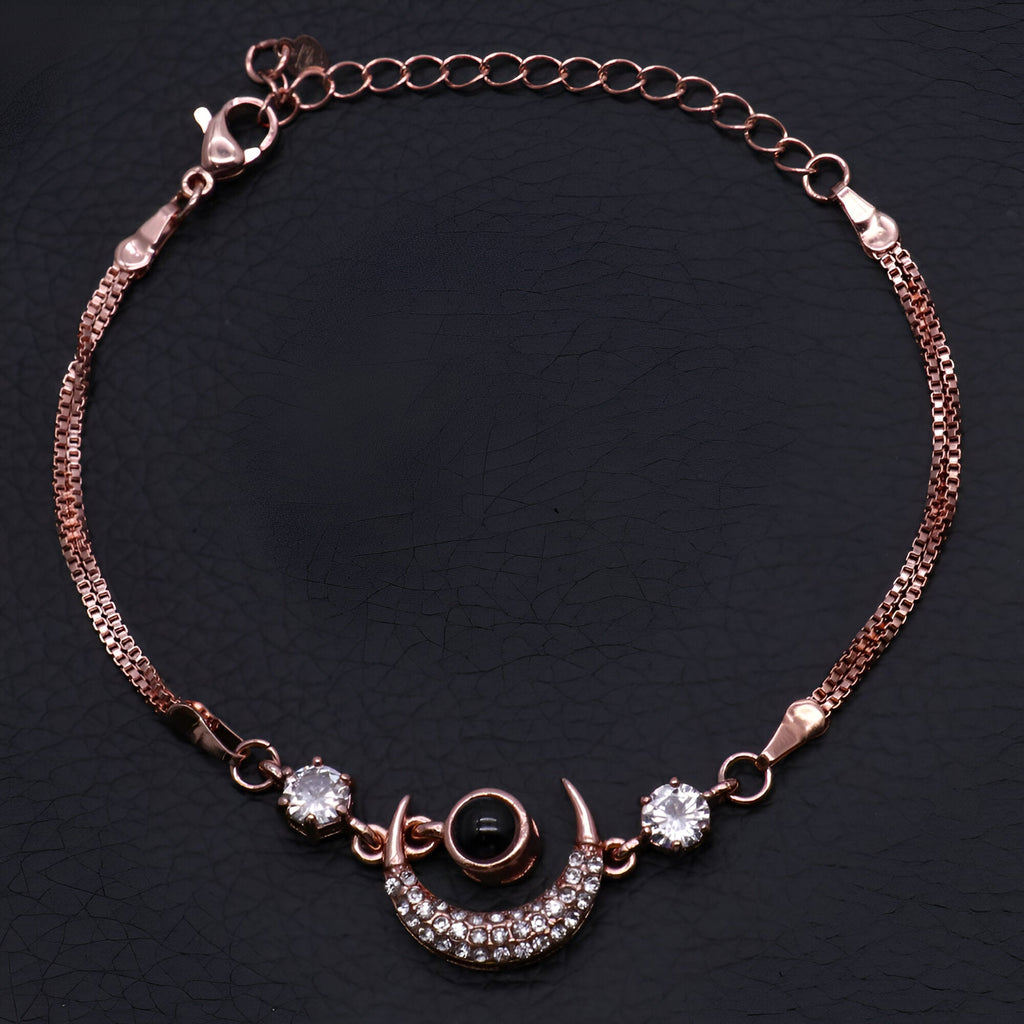 Bracelet en or rosé avec pendentif lune orné de pierres brillantes et chaîne fine élégante.