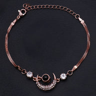 Bracelet en or rosé avec pendentif lune orné de pierres brillantes et chaîne fine élégante.