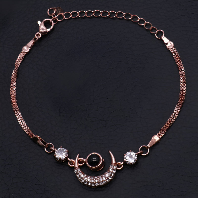Bracelet en or rosé avec pendentif lune orné de pierres brillantes et chaîne fine élégante.