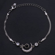 Bracelet en argent sterling avec pendentif lune orné de petits cristaux et deux pierres brillantes de chaque côté.