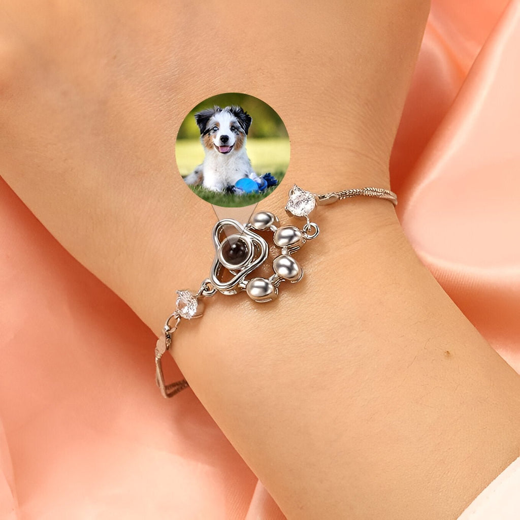 Bracelet en argent sterling avec pendentif patte de chien orné de pierres brillantes sur poignet féminin.