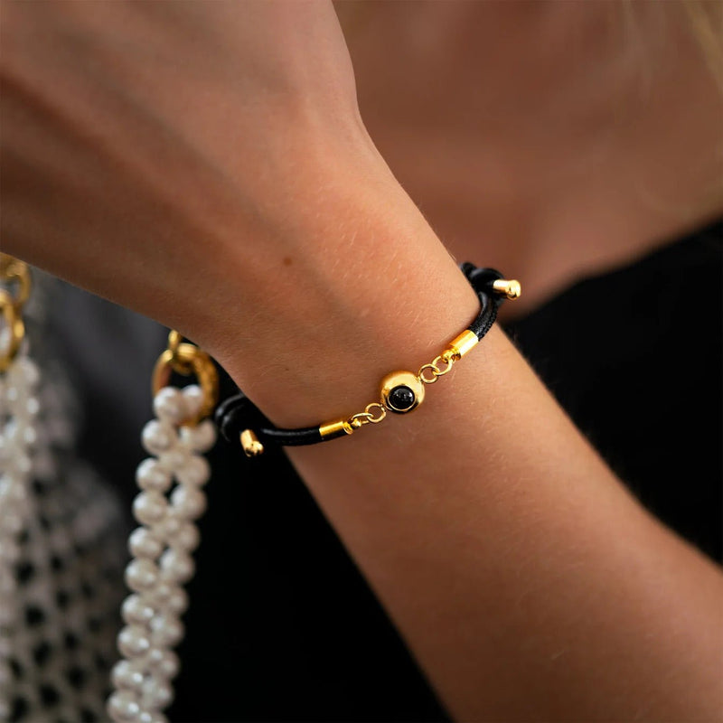 Bracelet en cuir noir avec plaque photo en acier inoxydable doré et perles métalliques dorées.