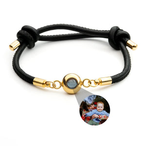 Bracelet en cuir noir avec fermoir en acier inoxydable doré et médaillon photo rond personnalisable.