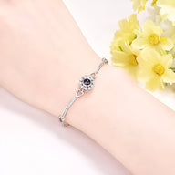 Bracelet en argent fin avec pierre noire centrale en oxyde de zirconium et détails délicats.