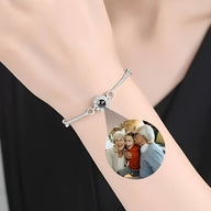 Bracelet fin en argent avec médaillon photo circulaire et zirconium noir sur poignet féminin.