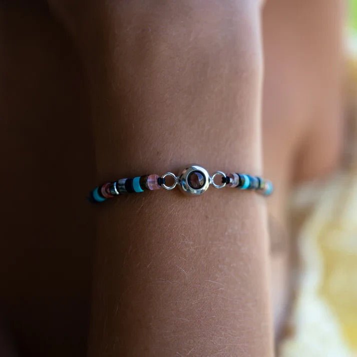 Bracelet fin en pierres heishi multicolores avec médaillon photo rond argenté, style bohème élégant.